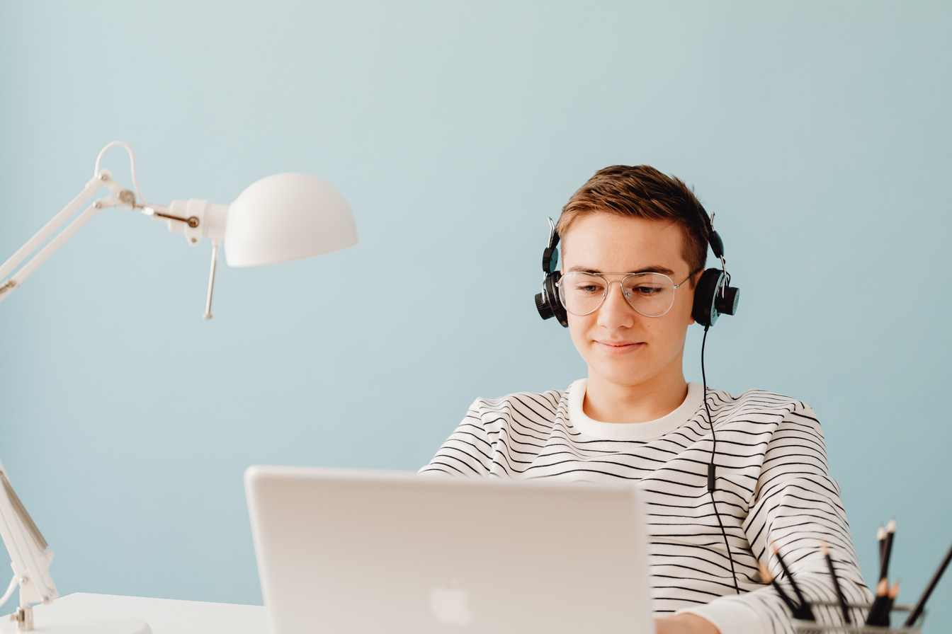 Teenage Boy in Headphones Working on Computer